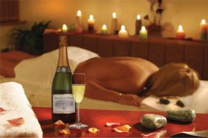 een vrouw op een bed met een fles wijn bij Les Hauts de Lastours in Belvès