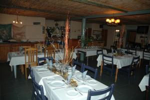 una sala da pranzo con tavoli bianchi e sedie blu di Traveller's Rest a Clanwilliam