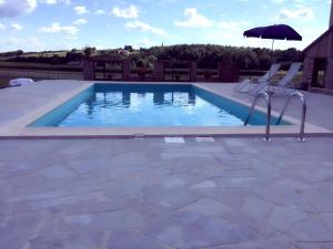 uma piscina com duas cadeiras e um guarda-sol em Apartments Mali Raj em Dolenci