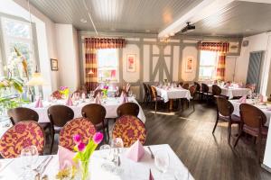 uma sala de jantar com mesas e cadeiras com flores em Hotel Werner em Mornshausen