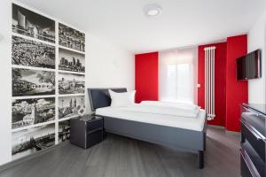 a bedroom with a bed and a red wall at Hotel Werner in Mornshausen