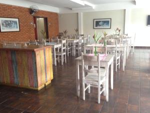 a dining room filled with tables and chairs at Hotel Colonial Aquarius in João Monlevade