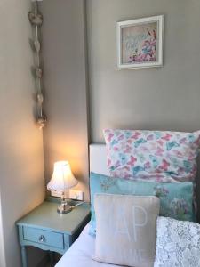 a bedroom with a bed and a lamp at Bay Breeze Guesthouse in Gordonʼs Bay
