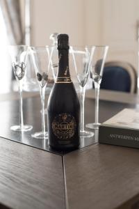 una bottiglia di champagne seduta su un tavolo con bicchieri da vino di Roaring 20's Apartment Meir ad Anversa