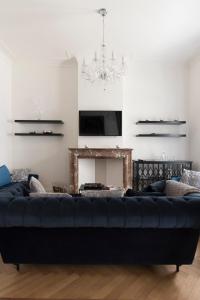 a black couch in a living room with a fireplace at Roaring 20's Apartment Meir in Antwerp