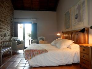 een slaapkamer met een groot bed met een houten hoofdeinde bij El Turcal in Torremenga