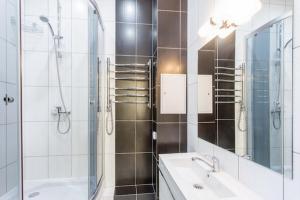 a bathroom with a shower and a sink and a mirror at Aparton Engelsa 28 in Minsk