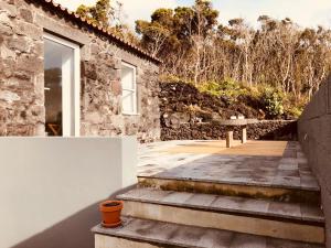マダレナにあるCasa d'Avó Franciscoの石造りの家の外の景色を望むパティオ付