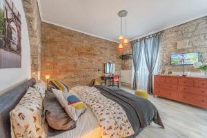 sypialnia z łóżkiem i ścianą z cegły w obiekcie Porta d'Oro rooms w Puli
