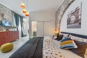 sypialnia z dużym łóżkiem i kamienną ścianą w obiekcie Porta d'Oro rooms w Puli