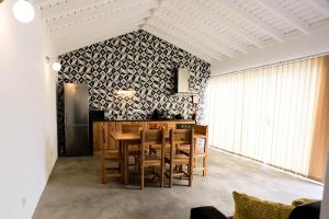 a kitchen with a table and chairs and a refrigerator at Casa do Sal in Madalena
