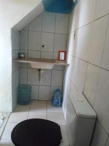 Baño pequeño con aseo y estante en estudio, en Salvador