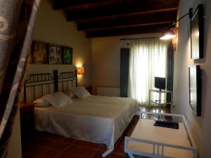 a bedroom with a white bed and a window at El Turcal in Torremenga