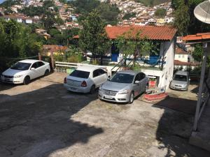 tres autos estacionados en un estacionamiento frente a una casa en Pousada Ciclo do Ouro, en Ouro Preto