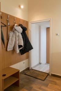 Walkway Apartment Deluxe في بودابست: غرفة مع خزانة مع مجموعة من الملابس