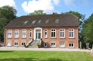a large red brick house with white windows at Ferienhof BauerMüller in Fehmarn