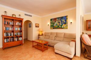 - un salon avec un canapé et une étagère à livres dans l'établissement Carabeo 52 Apartments Casasol, à Nerja