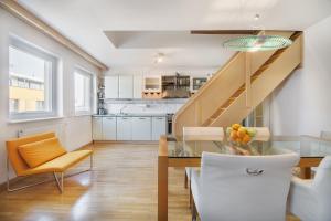 cocina y comedor con mesa de cristal y escaleras en Apartment Fine Dalmatinova, en Liubliana