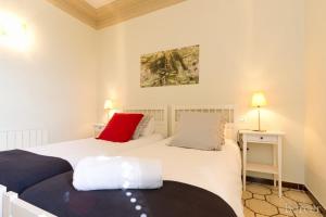 two beds in a bedroom with a red pillow at Armapana in Barcelona