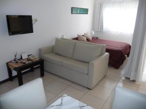 a living room with a couch and a bed at Rincón Del Golf in Pinamar