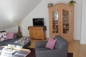 a living room with two couches and a tv at Ferienwohnung Kredig in Poppenhausen