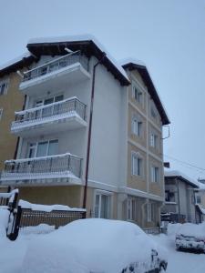 budynek z śniegiem przed nim w obiekcie Horizont Dobrinishte w mieście Dobriniszte