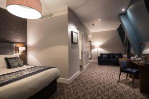 een hotelkamer met een bed en een bank bij The Troll Cart Wetherspoon in Great Yarmouth