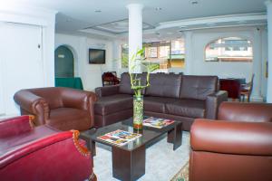 sala de estar con mesa y muebles de cuero marrón en Hotel Ecoinn, en Bogotá