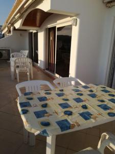 einen Tisch mit Stühlen und eine Decke darüber in der Unterkunft Apartamento Varandas do Mar AL63644 in Albufeira
