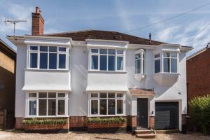 una casa blanca con muchas ventanas en Dale House - Vivre Retreats, en Bournemouth