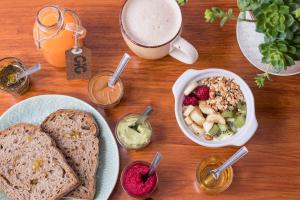 a table with a plate of food and a cup of coffee at GiG Capsule Hostel in Ericeira +37 photos