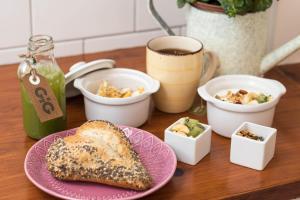 a table with a plate of bread and bowls of food at GiG Capsule Hostel in Ericeira