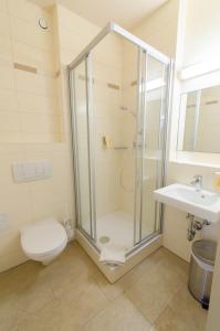 a bathroom with a shower and a toilet and a sink at JUFA Hotel Graz City in Graz