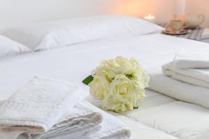 オルビアにあるSanpietroburgo 22の白い花がベッドに掛けられており、タオルが付いています。