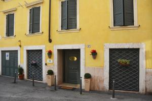 a yellow building with two doors and plants on the front at Relais Ponte Pietra in Verona
