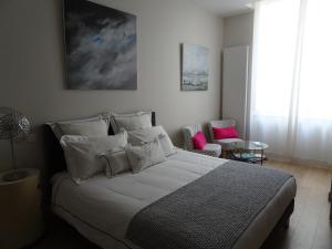 ラ・ロシェルにあるCalme et sérénitéのベッドルーム(白い枕の大型ベッド1台付)