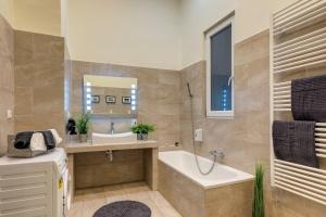 a bathroom with a tub and a sink and a bath tub at Real Apartments Klauzál in Budapest