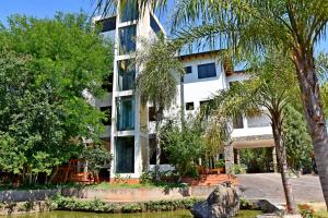a building with trees in front of it at Los Lagos Resort Hotel in Capiatá