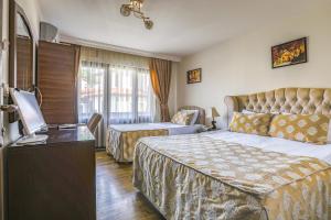 a hotel room with two beds and a television at Hotel Ankatra in Ankara