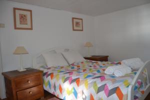 a bedroom with a bed with a colorful comforter at Casal São João Cottages 106 in Fajã da Ovelha