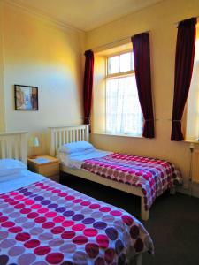 a bedroom with two beds and a window at The Apothecary Guest House in Haworth