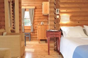 a bedroom in a log cabin with a bed and a desk at Xenios Chalet in &Aacute;no Kh&oacute;ra