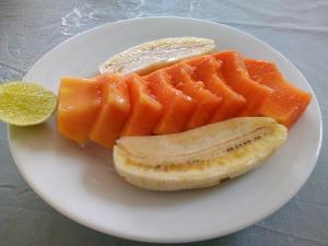 a plate of fruit with a banana and orange slices at First House Mihintale in Mihintale +20 photos