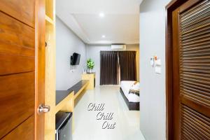 a room with a bed and a door with the words chill chill out at Hobby Hotel in Uttaradit