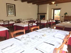 une salle à manger avec tables et chaises et nappes blanches dans l'établissement Agriturismo L'Ulivo, à Padula