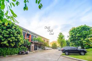 a black suv parked in front of a building at Hobby Hotel in Uttaradit