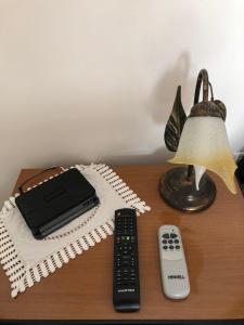 a table with a remote control and a lamp at La Terrazza al tramonto CITRA in Lerici