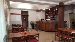 un ristorante con tavoli e sedie in legno e un bar di Osteria Belvedere a Losone