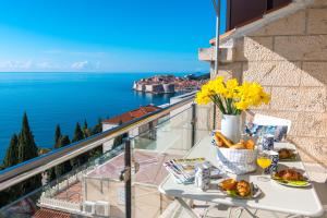 una mesa con comida y vistas al océano en Two Palm Trees Apartment, en Dubrovnik