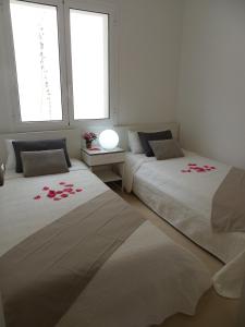 トッサ・デ・マールにあるDANLUX MOLI 12の花が飾られた部屋のベッド2台